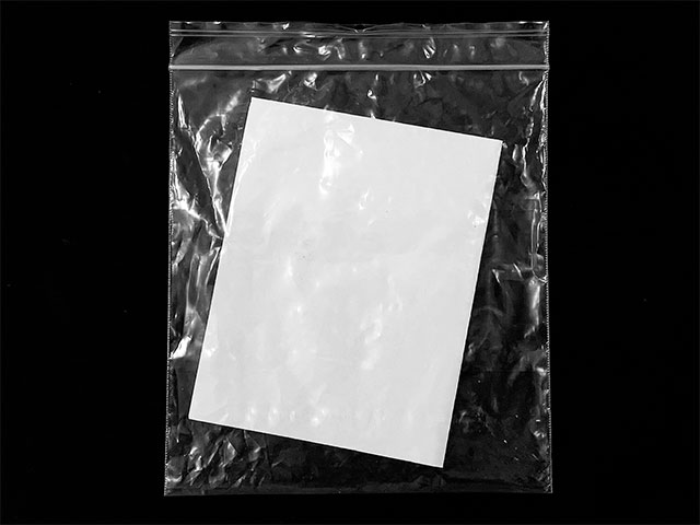 a clear plastic resealable bag with a white standard sheet of printer paper inside