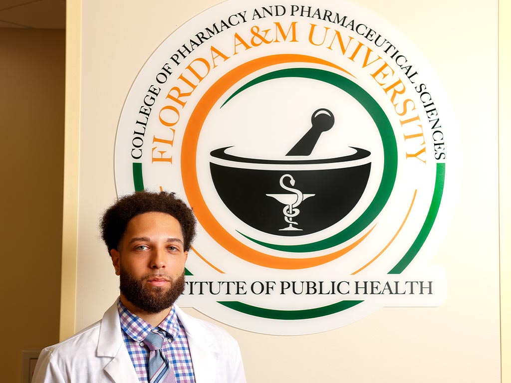Student standing in front of IPH sign