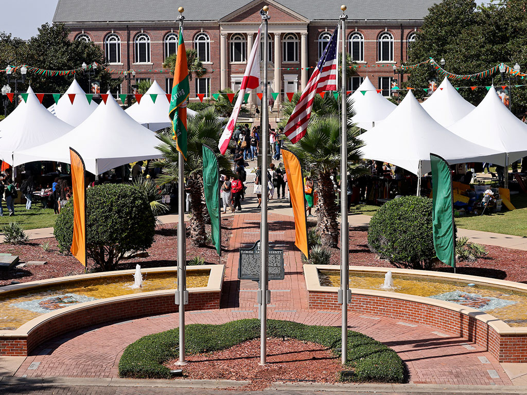 FAMU Market with white tents and orange and green flags in front of Coleman Library