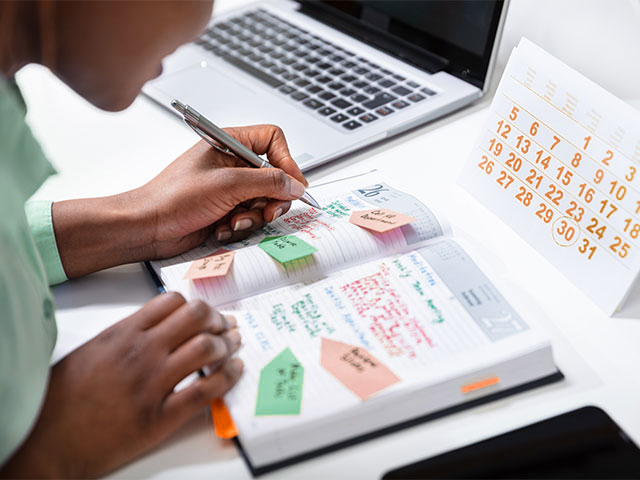 Woman writing in calendar