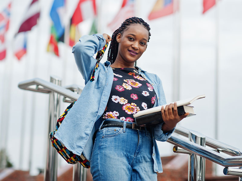 International Student standing in front of various nation's flags