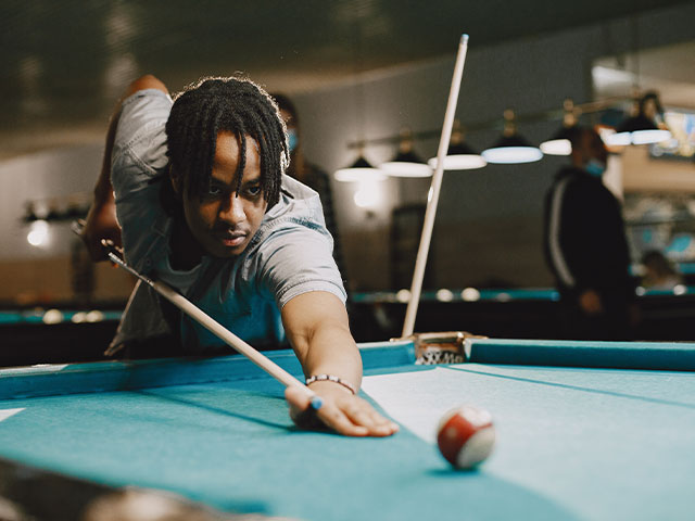 Student playing billiards