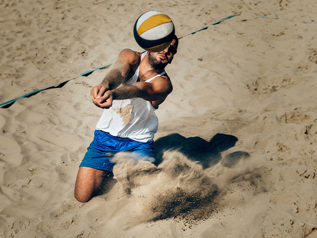 Student playing sand volleyball