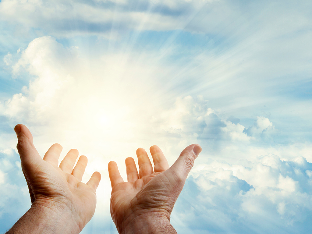 Hands reaching upward to the sun in a vibrant blue sky.