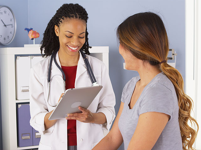 Nurse handing medicine to patient