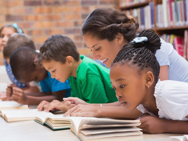 Teacher helping students with reading