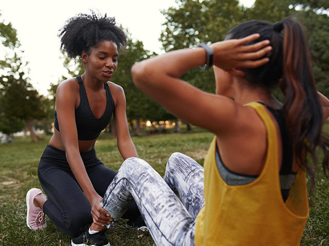 Female Personal Trainer Helping her client with situps