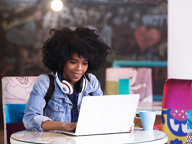 happy female student using laptop