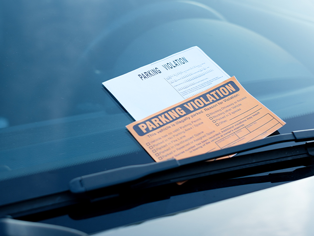 an orange Parking Violation Ticket on windsheld of a car