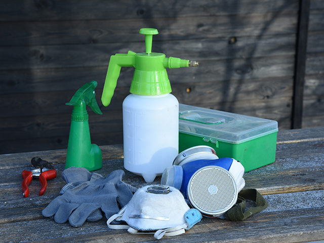Close up of a set of Garden maintenance tools pruner gloves sprayer garden first aid kit and respirator. 