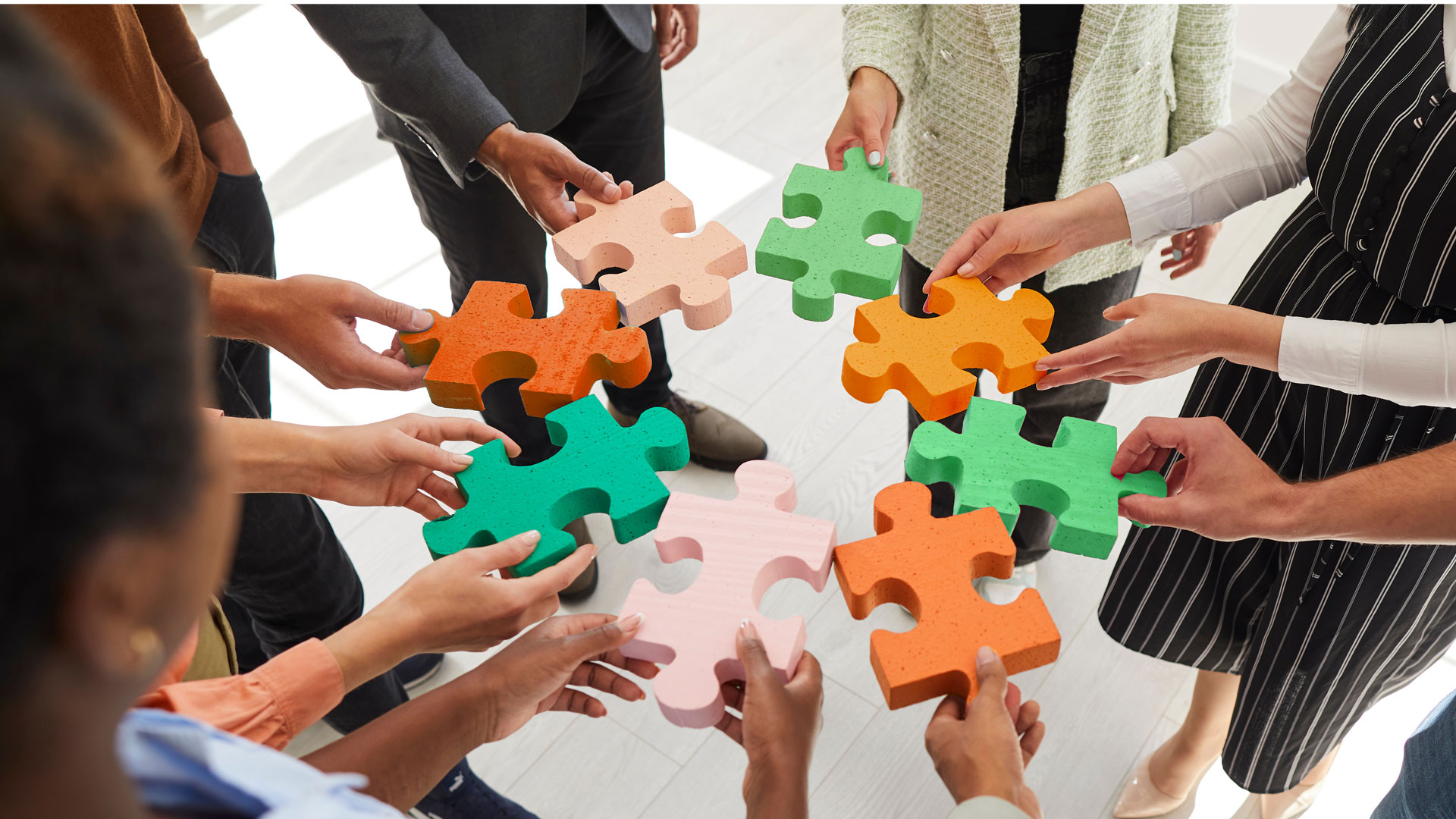 HR works holding green and orange puzzle pieces