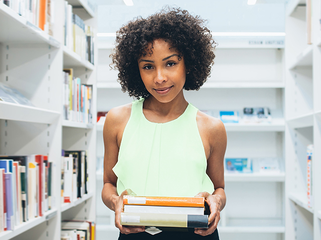 Girl in bookstore holding books