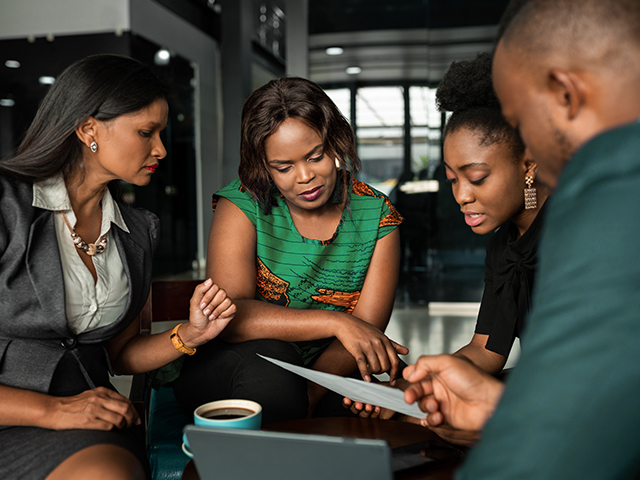 African American businesspeople discussing paperwork together during an office meeting