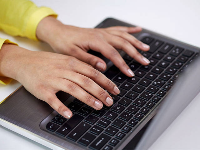 Student typing on laptop