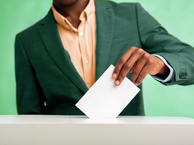 African american man putting his vote into a ballot box