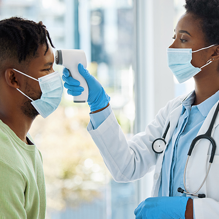 black female doctor taking the temperature of her patient