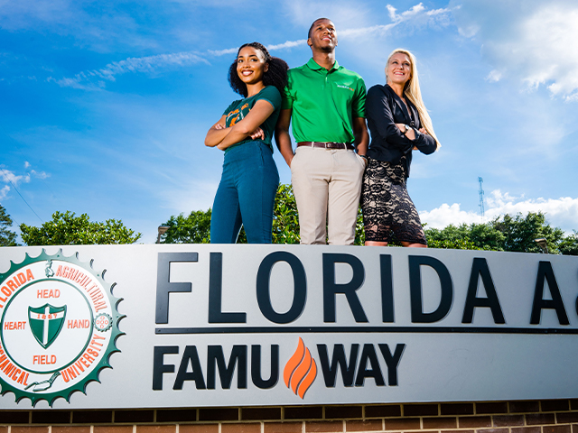 Three FAMU Students Standing behind "FAMU Way" sign