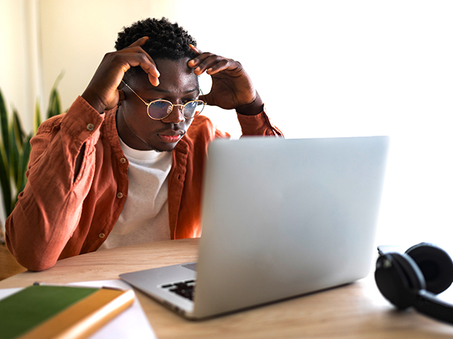 overwhelmed man sitting in front of laptop