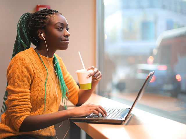 student using laptop by window