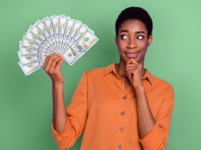 Student thinking while holding a fan of money