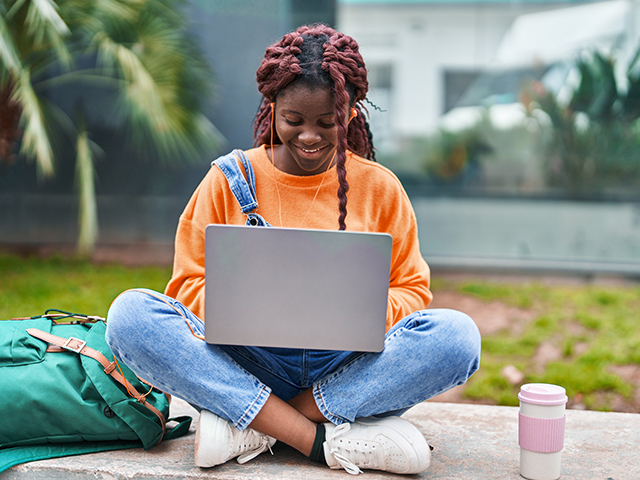 student using laptop outside