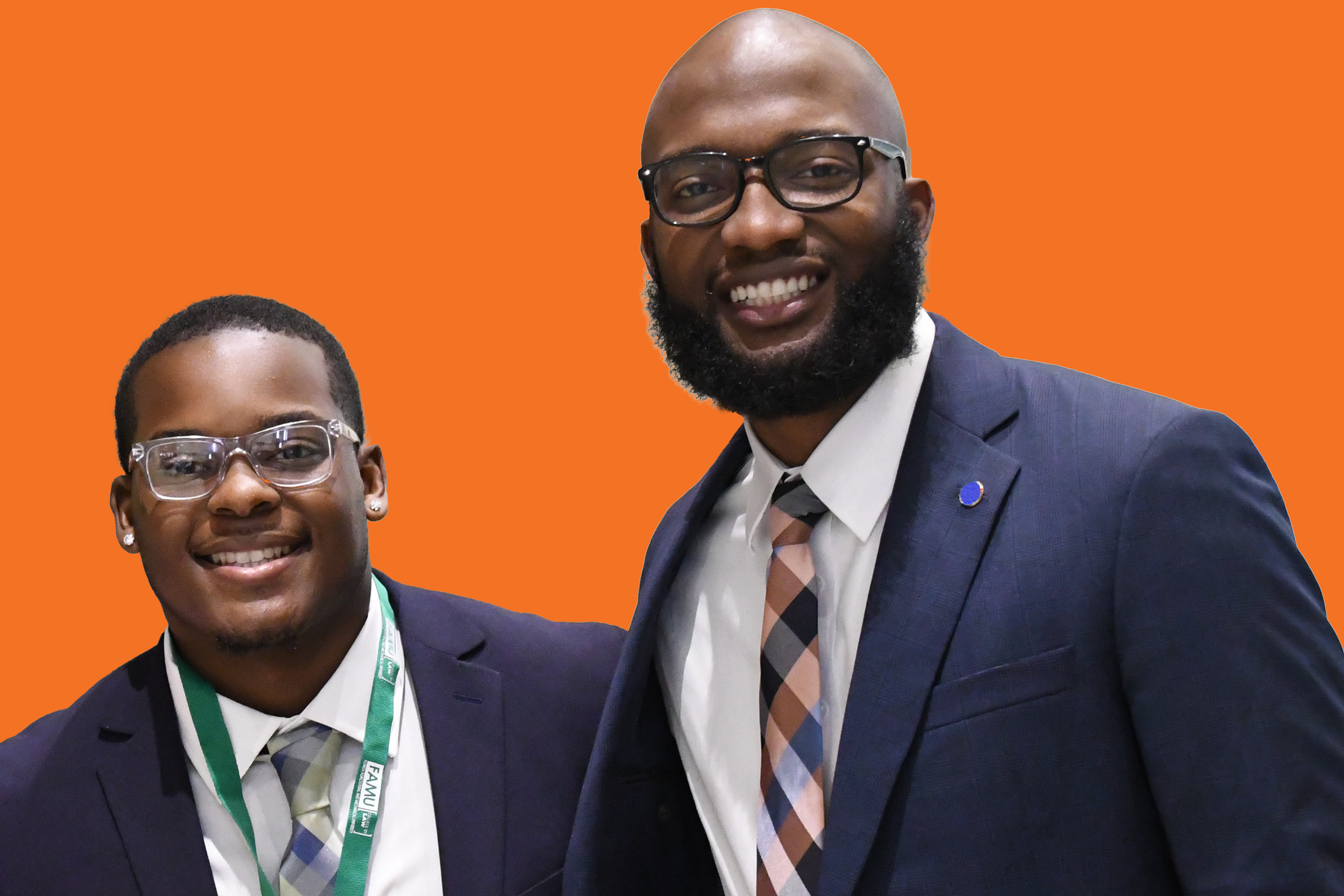 Two African American men in suits smilling with an orange background