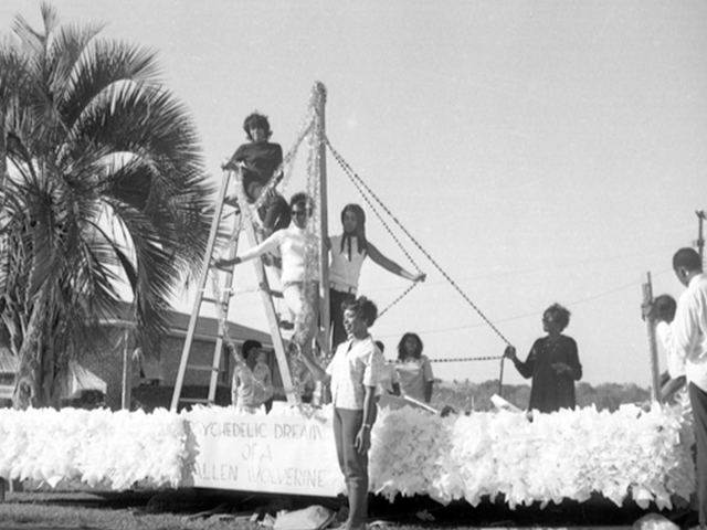 Note side of float reads, "Psychedelic dream of a fallen wolverine"[mascot of rival football team].  Students working on the float include: Carole Dennard, Barbara Duncan, Gertrude Peoples, Sharon McCloud and Helen Polite