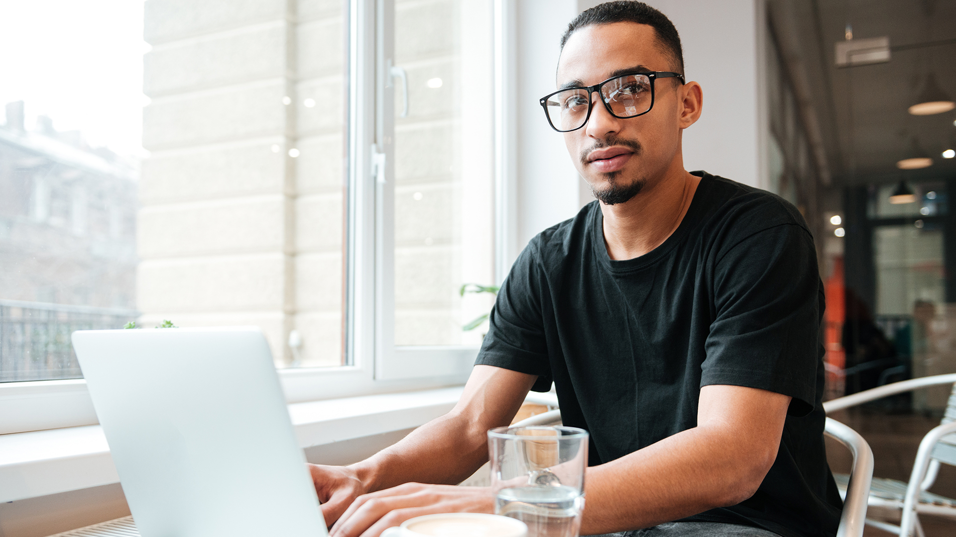 young man using laptop in cafe.